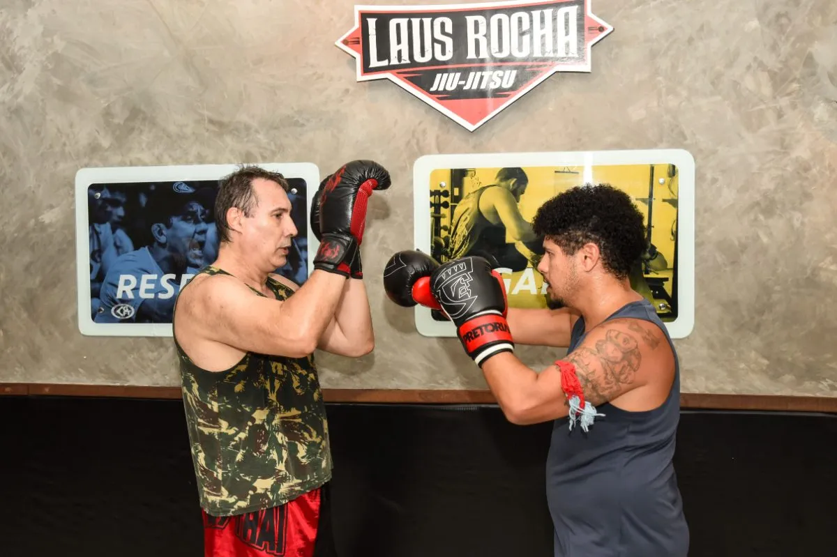 Dois alunos treinando golpes de Muay Thai com luvas