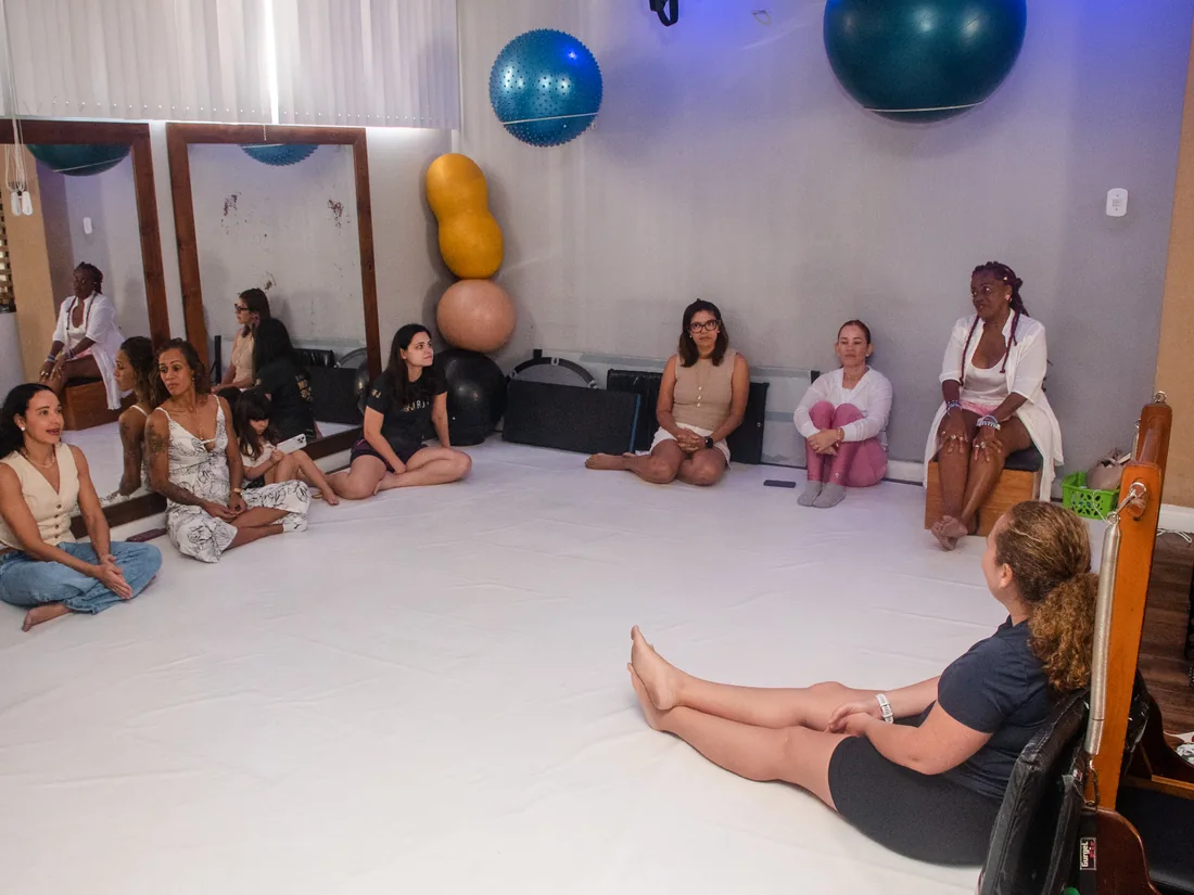Roda de conversa entre as participantes, sentadas no chao da sala