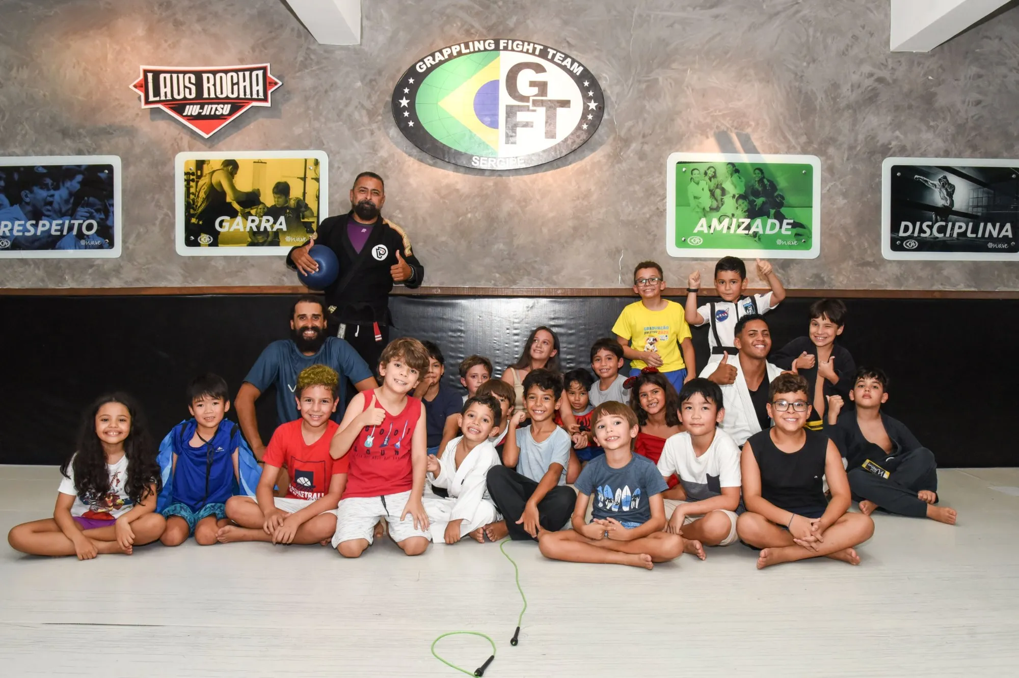 Turma infantil de jiu-jitsu reunida no tatame com os professores