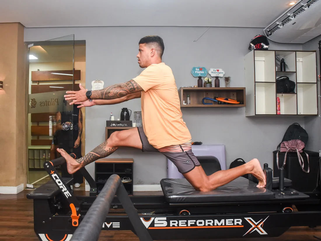 Sala de Pilates com aparelhos e alunos em aula