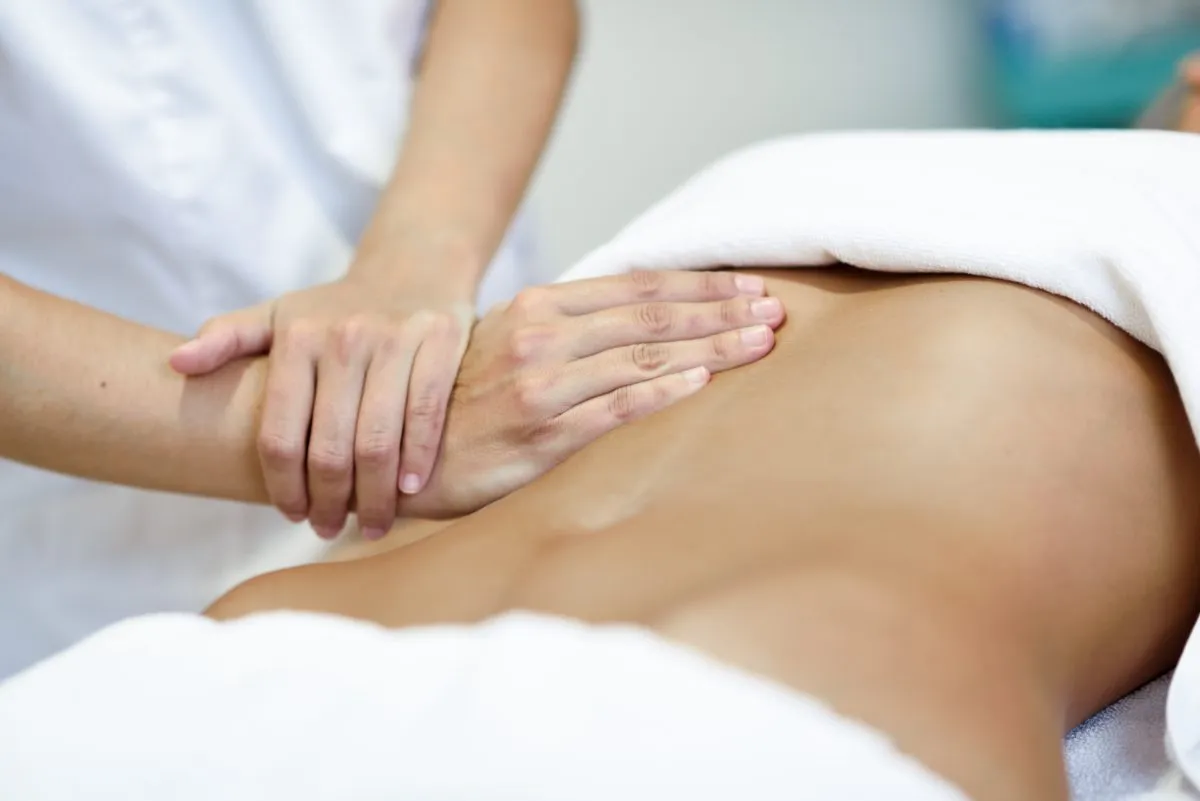 Profissional realizando tratamento corporal no abdômen