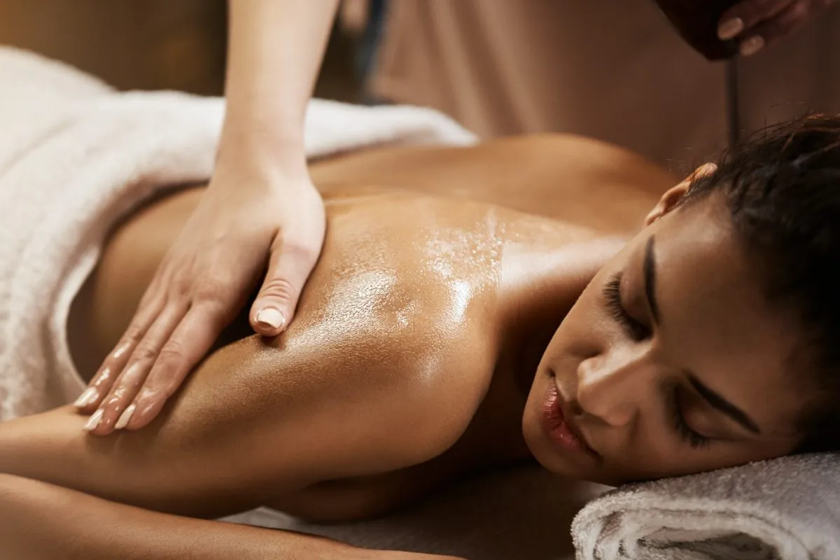 Terapeuta realizando massagem nas costas de uma cliente